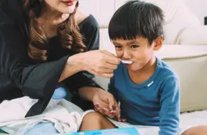 child taking liquid medicine