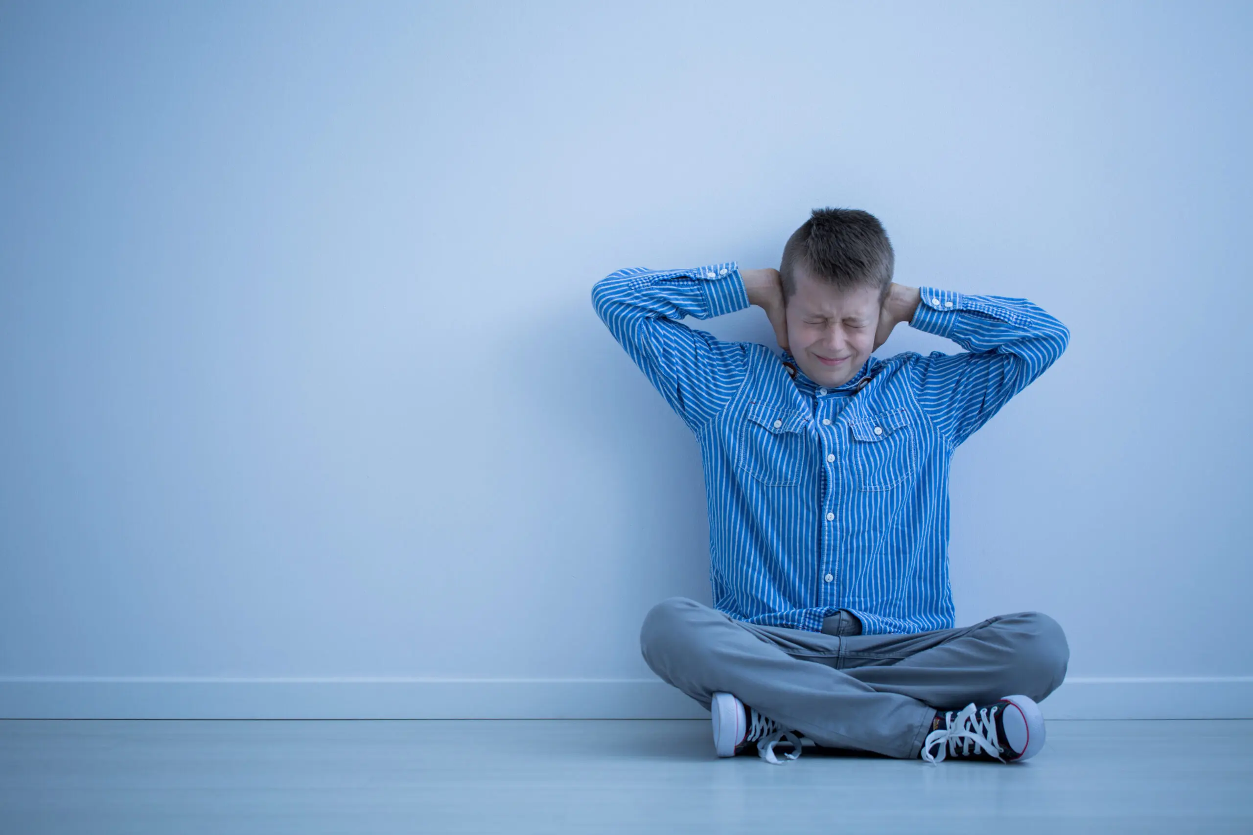 little boy holding his ears
