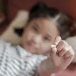 small child holding medication