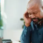 man touching head because of headache