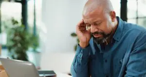 man touching head because of headache