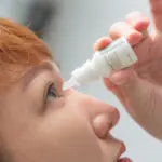 woman putting in eye drops