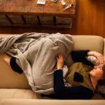 woman looking tired laying on couch