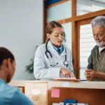 female doctor speaking to older male patient
