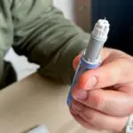 person holding ozempic pen