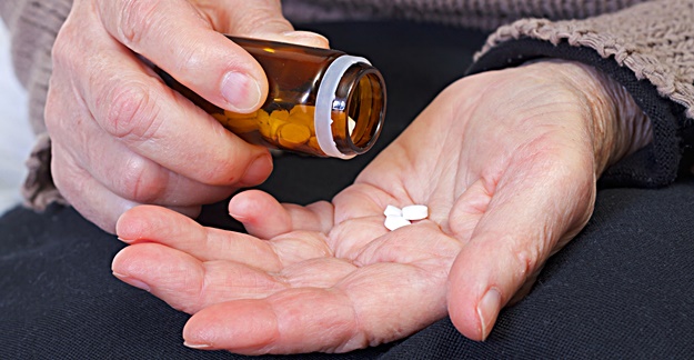 person pouring pills in hand