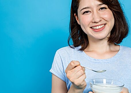 woman eating probiotic yogurt for benefits of probiotics
