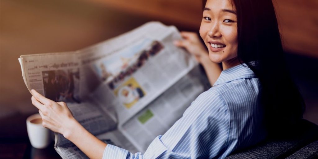 Asian Woman Reading trustworthy health info Newspaper