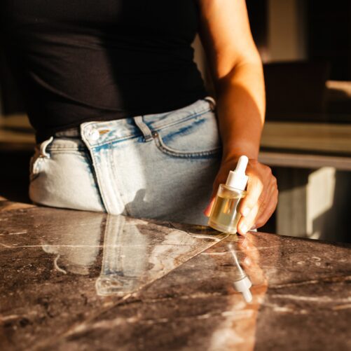 woman holding oil at kitchen counter