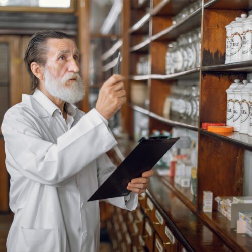 pharmacist looking at drugs on shelf