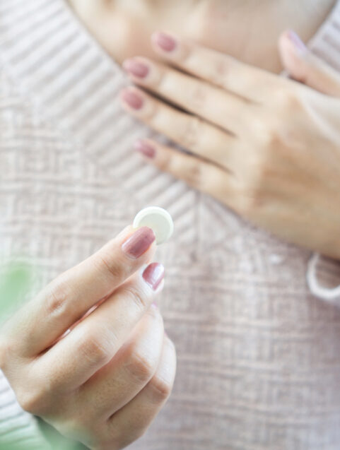 female hand holding antiacid, tums