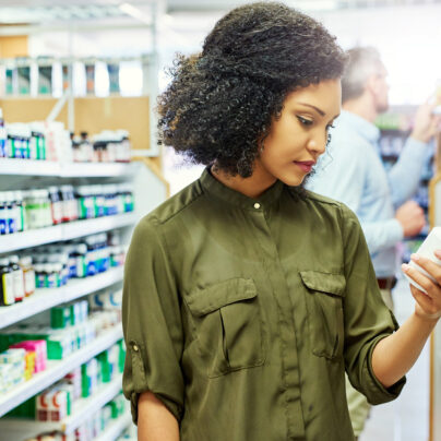 woman looking at pill bottles in store, Benadryl