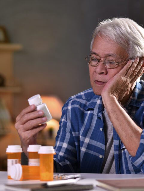 medication safety for older adults, older man looking at pill bottles