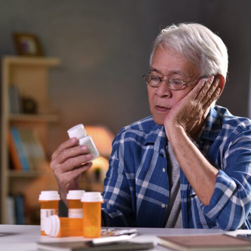 medication safety for older adults, older man looking at pill bottles