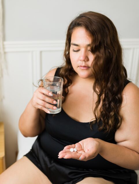 Migraine Drugs and High Blood Pressure, Circulation Problems , woman about to take tablet