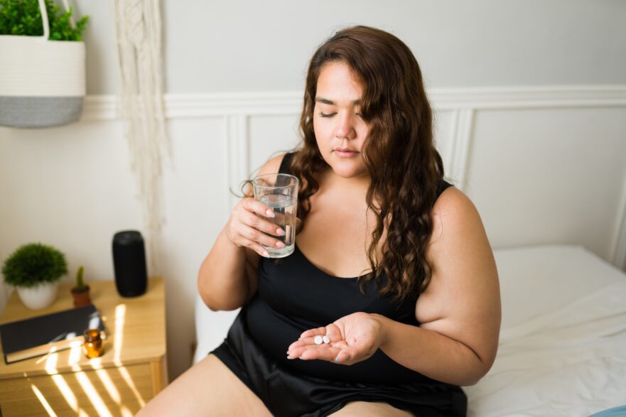 Migraine Drugs and High Blood Pressure, Circulation Problems , woman about to take tablet