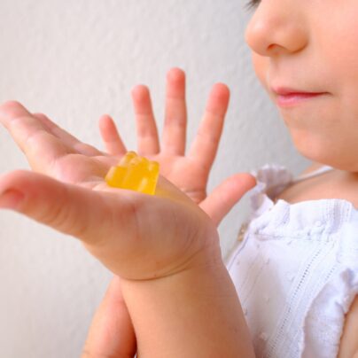 small child holding melatonin gummy