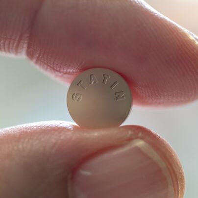 statins, side effects and cholesterol, fingers holding stain pill