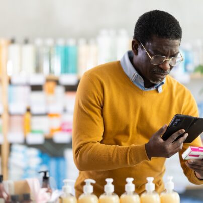 Older man looking at medicine in drug store, PPIs and dementia link