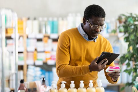 Older man looking at medicine in drug store, PPIs and dementia link