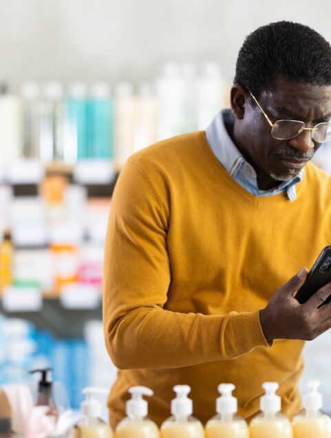 Older man looking at medicine in drug store, PPIs and dementia link
