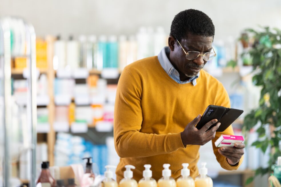 Older man looking at medicine in drug store, PPIs and dementia link