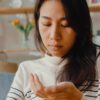 Gabapentin and Pregabalin Withdrawal Risks, young woman looking at pills