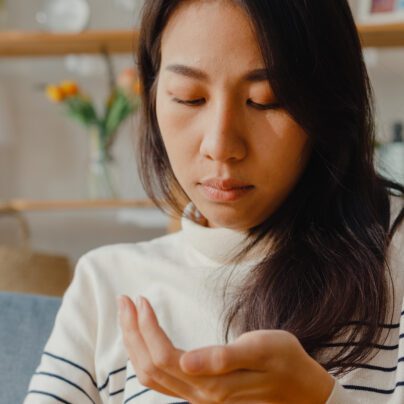 Gabapentin and Pregabalin Withdrawal Risks, young woman looking at pills