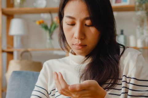 Gabapentin and Pregabalin Withdrawal Risks, young woman looking at pills