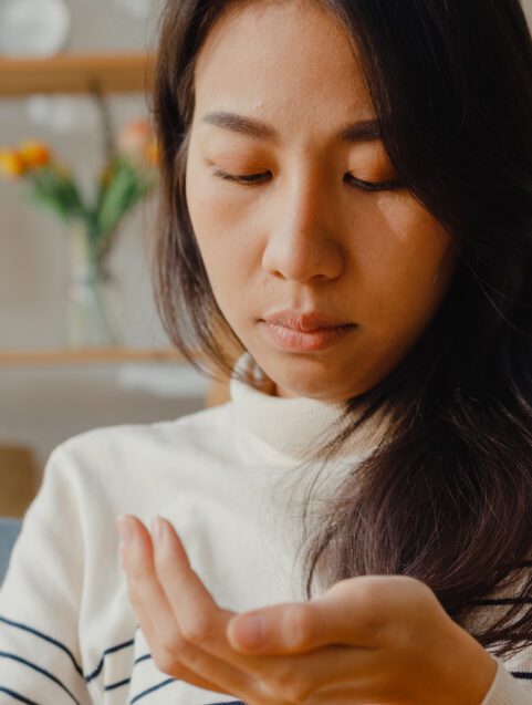 Gabapentin and Pregabalin Withdrawal Risks, young woman looking at pills