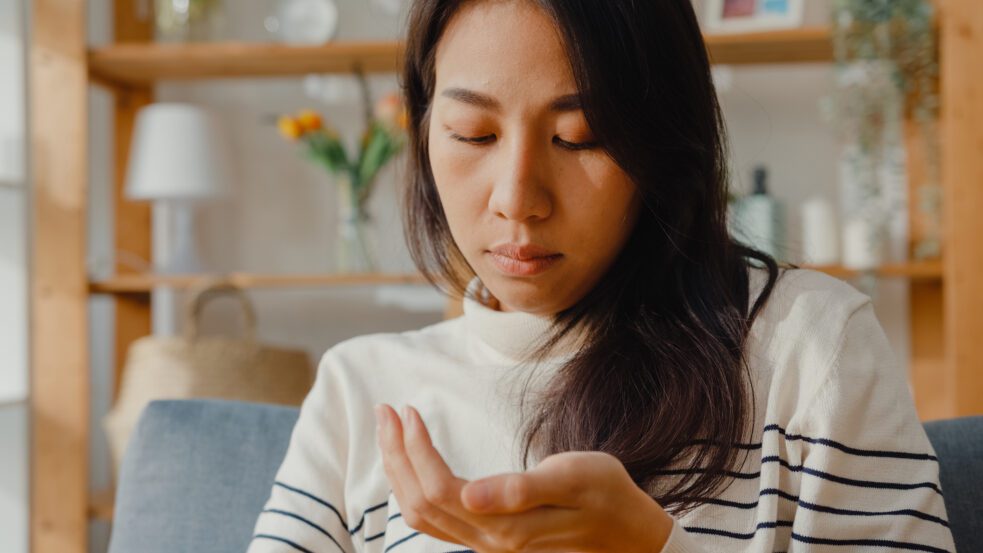 Gabapentin and Pregabalin Withdrawal Risks, young woman looking at pills