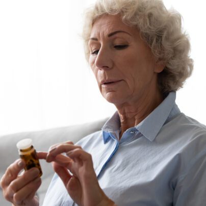 drug recalls and warnings, woman looking at pill bottle