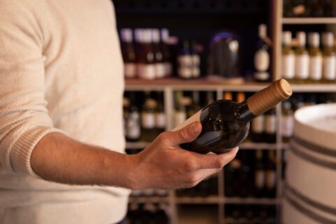 Ozempic and Alcohol, man looking at wine bottle