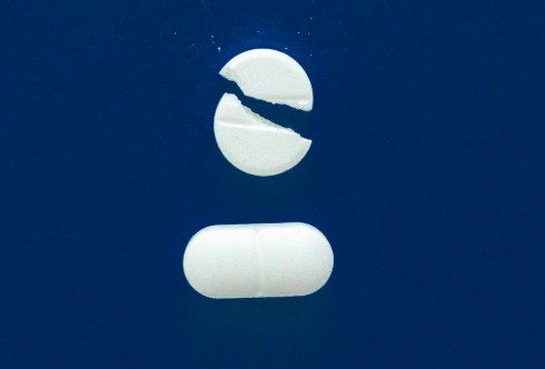 broken pill on blue background