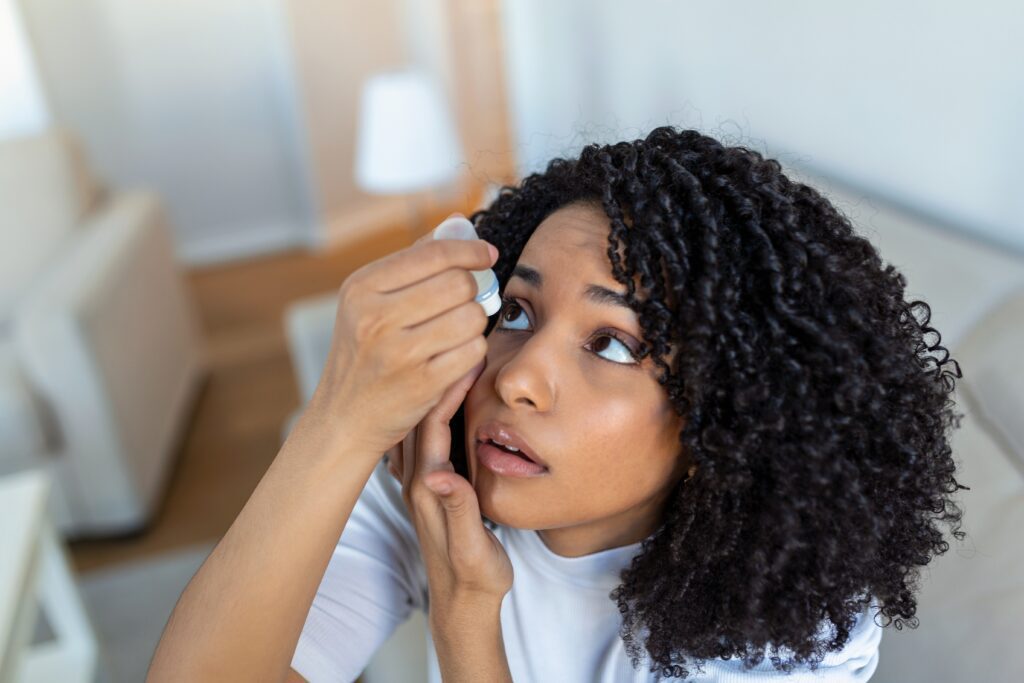 young woman putting in eye drops