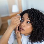 young woman putting in eye drops