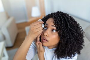 young woman putting in eye drops