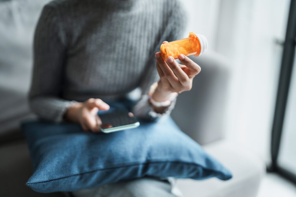 woman looking at pill bottle