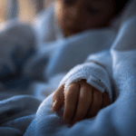 sick child in a hospital with a bandage on their hand