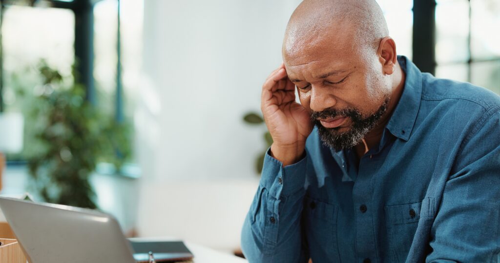 man touching head because of headache