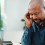 man touching head because of headache