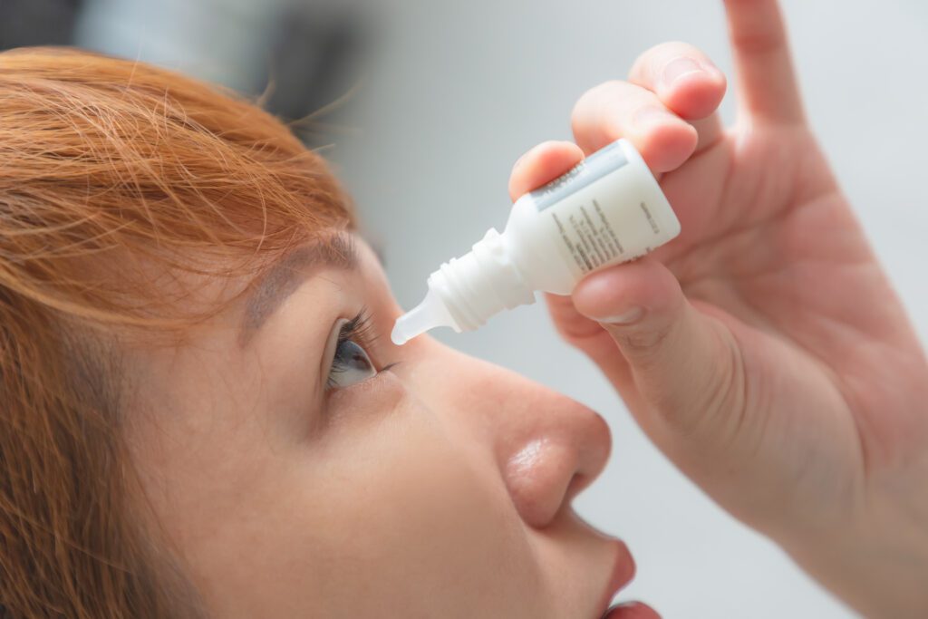 woman putting in eye drops