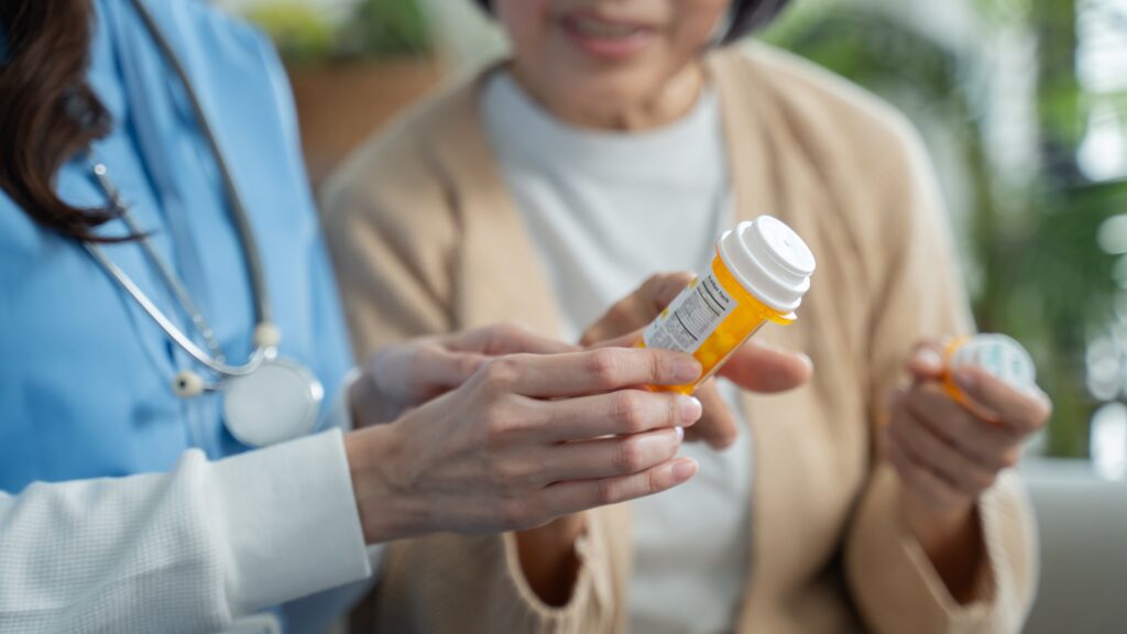 doctor handing pills to older woman