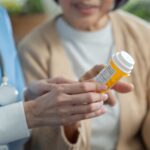 doctor handing pills to older woman